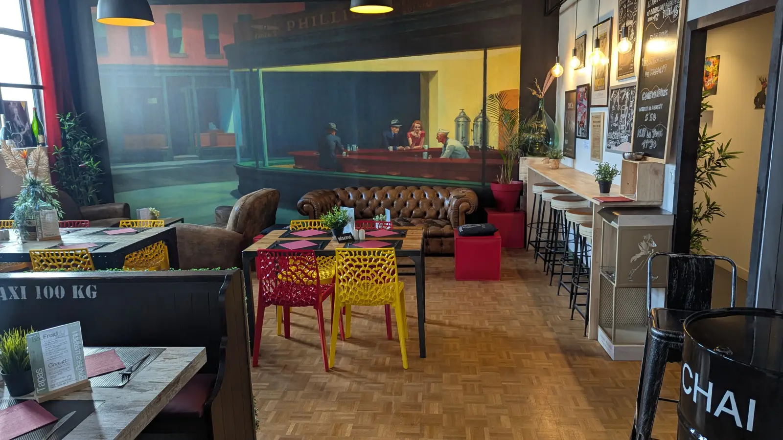 La salle d'Urban Food au Chai N°5 : fresque façon Hopper, canapé Chesterfield et chaises colorées